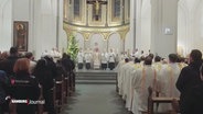 Menschen sitzen in einem Gotttesdienst. © Screenshot 