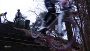 Cyclocross-Radler:innen fahren eine Treppe im Hamburger Volkspark hinunter. © Screenshot 