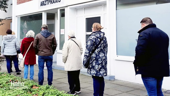 Menschen stehen Schlange vor einer Arztpraxis. © Screenshot 