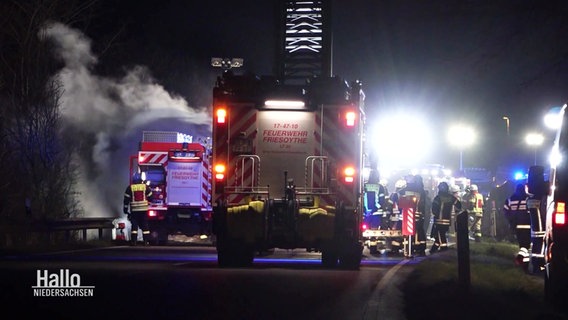 Fahrzeuge und Einsatzkräfte der Feuerwehr bei Dunkelheit auf einer Straße. © Screenshot 