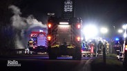 Fahrzeuge und Einsatzkräfte der Feuerwehr bei Dunkelheit auf einer Straße. © Screenshot 