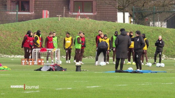 Fußballspieler stehen bei einer Trainingseinheit im Kreis auf dem Feld. © Screenshot 