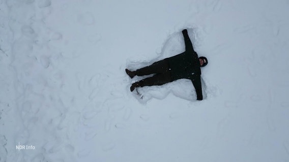 Vogelperspektive: Eine Person macht einen Schneeengel. © Screenshot 