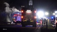 Im Einsatz: Fahrzeuge und Einsatzkräfte der Feuerwehr bei Dunkelheit auf einer Straße. © Screenshot 