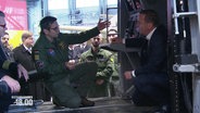 Verteidigungsminister Boris Pistorius in einem Marineflieger, im Gespräch mit einem Piloten. © Screenshot 