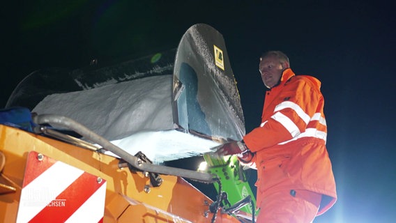 Maxim Jackel vom Winterdienst lädt Salz auf sein Streufahrzeug auf. © Screenshot 