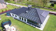 Vogelperspektive: Ein Haus mit Solarzellen auf dem Dach (Archivbild). © Screenshot 