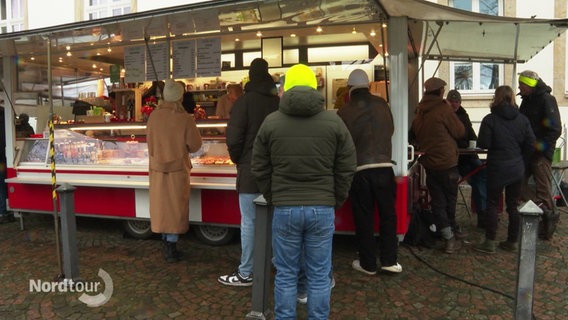 Menschen stehen bei einem Stand auf dem Wochenmarkt an. © Screenshot 