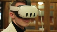 Ein junger Mann trägt eine VR-Brille. © Screenshot 