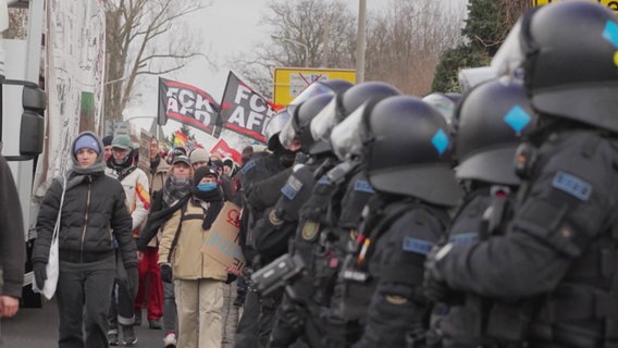 Protestierende laufen an einem Polizeispalier vorbei. © Screenshot 