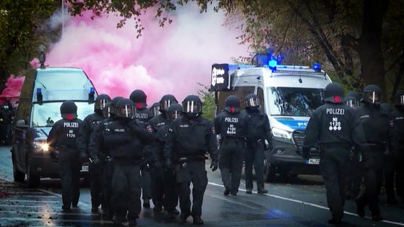 Polizeibeamte sichern einen Fanmarsch. © Screenshot 