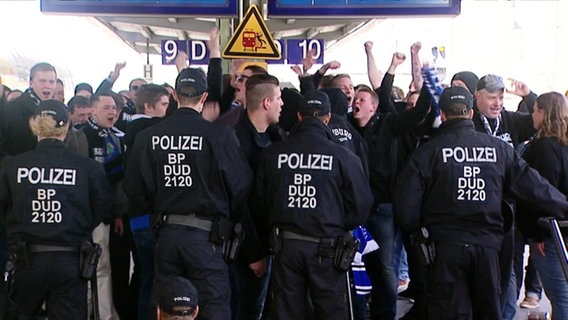 Polizisten halten Fußballfans zurück. © Screenshot 