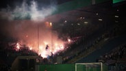 Im Fanblock eines Fußballstadions brennt Pyrotechnik. © Screenshot 