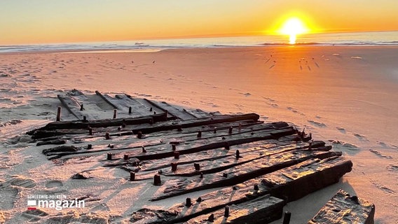 Ein Schiffswrack liegt an einem Strand im Sonnenuntergang. © Screenshot 