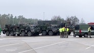 Fahrzeuge einer Bundeswehr-Kolonne machen an einer Autobahn-Raststätte halt. © Screenshot 