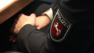 .uf einem Pullover ist das logo der niedersächsichen Polizei zu sehen. © Screenshot 