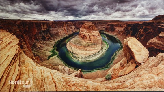 Blick auf einen gebogenen Fluss am Grund eines Canyons © Screenshot 