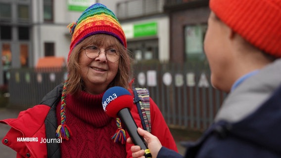 Eine Frau mit bunter Strickmütze wird interviewt © Screenshot 