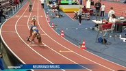 Bei einer Hallenmeisterschaft in Leichtathletik stehen Läuferinnen in ihren Startpositionen auf den Bahnen. © Screenshot 