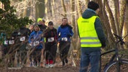 Läuferinnen und Läufer laufen bei einem Spendenlauf durch einen Wald. © Screenshot 