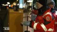 Eine Frau der Hilfsorganisation Malteser verteilt Essen an Obdachlose. © Screenshot 