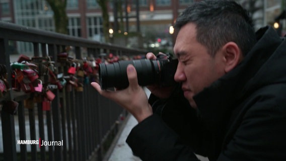 Der Künstler Liu Cheng-Hsiang aus Taiwan fotografiert auf Hamburgs Brücken die dort angebrachten Liebesschlösser. © Screenshot 