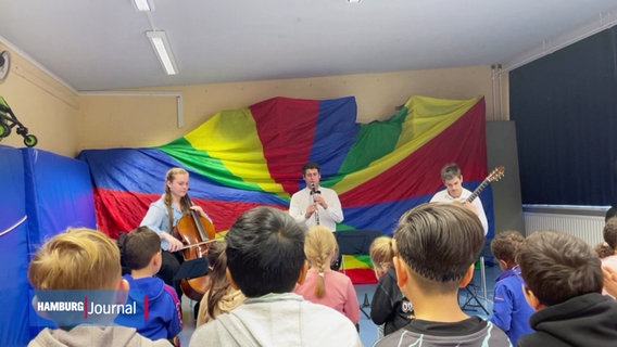 Ein Konzert vor Kindern und Jugendlichen auf einer bunten Bühne. © Screenshot 