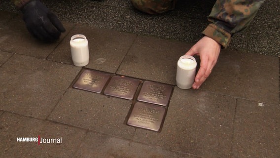 Neben geputzten Stolpersteinen werden Kerzen aufgestellt. © Screenshot 