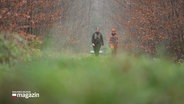 Zwei Frauen laufen auf einer Lichtung durch den Wald. © Screenshot 