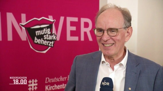 Ralf Meister, Landbischof von Niedersachsen, vor pinken Stellwand im Interview © Screenshot 