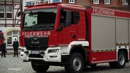 Ein großes Einsatzfahrzeug der Feuerwehr steht auf einem Marktplatz. © Screenshot 