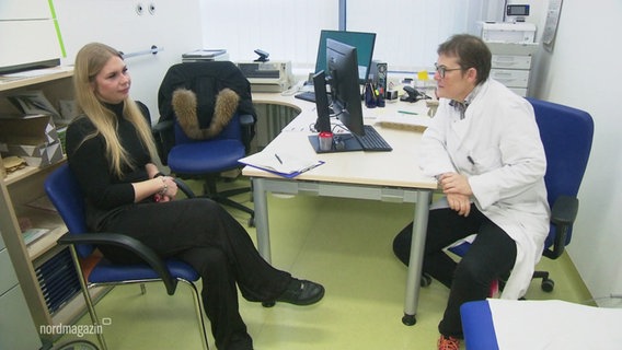 In einem behandlungszimmer einer Klinik sitzen sich eine Ärztin und eine Patientin gegenüber. © Screenshot 