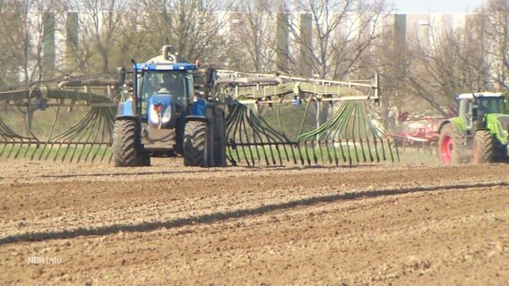 Ein Traktor düngt einen Acker. © Screenshot 