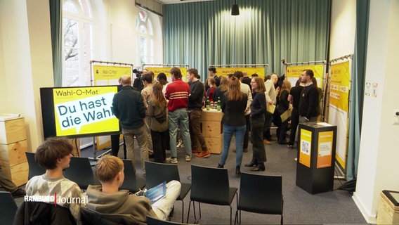 Schüler und Politiker stehen bei einer Veranstaltung zum Start des Wahl-O-Mats für die Bürgerschaftswahl zusammen. © Screenshot 