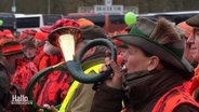 Eine Jägerin stößt bei einer Demonstration der Landesjägerschaft in ihr Horn. © Screenshot 