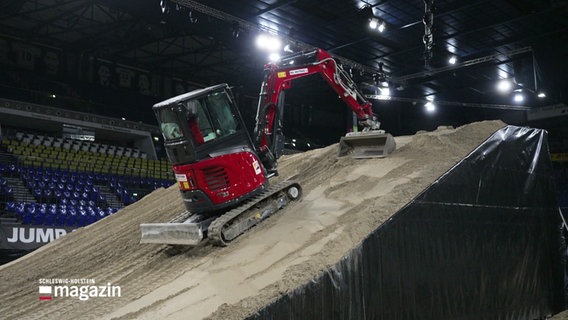 Ein Bagger präperiert eine Rampe für die Stuntshow. © Screenshot 