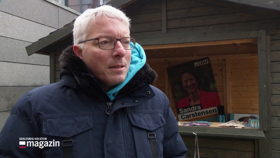 Arne Rüstemeier (CDU) vor einem Wahlkampfstand. © Screenshot 