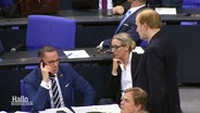 Blick in den Bundestag. AfD-Politiker Tino Chrupalla sitzt auf seinem Platz mit ernsten Gesicht und dem Handy am Ohr. © Screenshot 