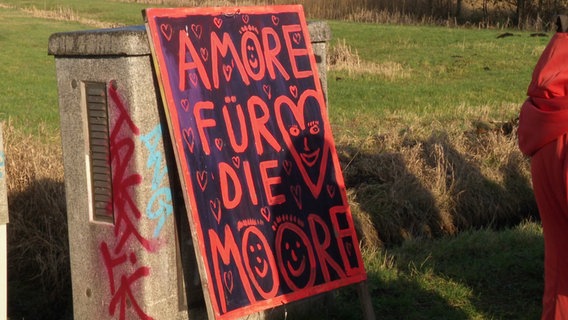 Ein Protestschild mit der Aufschrift: "Amore für die Moore". © Screenshot 