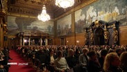 Viele Menschen sitzen bei einem Empfang im Rathaus. © Screenshot 