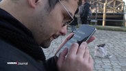 Ein sehbehinderter Mann benutzt eine Smartphone-App. © Screenshot 