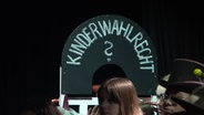 Ein Schild mit der Aufschrift "Kinderwahlrecht ?". © Screenshot 