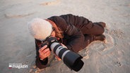 Kinka Tadsen liegt im Sand und fotografiert. © Screenshot 