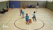 Viele Kinder spielen in einer Sporthalle. © Screenshot 