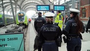 Mehrere Polizistinnen und Polizisten stehen am Gleis in einem Bahnhof. © Screenshot 