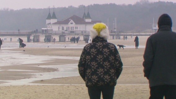 Urlauber laufen am Strand von Heringsdorf entlang. © Screenshot 