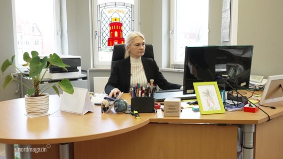 Eine Frau sitzt in einem Büro an einem Computer. © Screenshot 