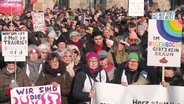 Teilnehmende an einer Demonstration mit Plakaten gegen Rechtsextremismus. © Screenshot 