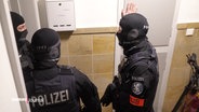 Polizeibeamte durchsuchen ein Gebäude in Jenfeld. © Screenshot 