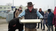 Künstler Gunther Demnig hält die Stolperschwelle für Pasewalk. © Screenshot 